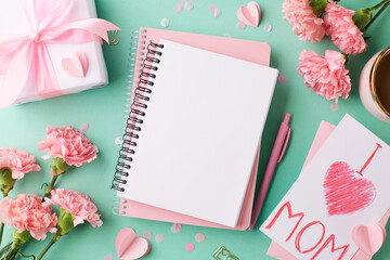 Mother's Day serenade: An inviting scene with a pristine gift, blank notebook, and blush carnations...