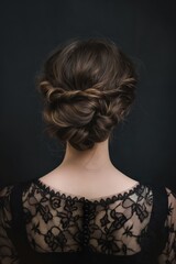 Sophisticated woman's updo featuring twisted locks on a dark backdrop, showcasing the intricacy of the hair design. Back view