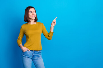 Photo of dreamy cute woman wear shirt looking showing finger empty space isolated blue color...