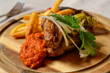 Cevapcici Balkan Style Meatballs with Ajvar Sauce, Onions, Parsley, French Fries and Grilled Pepper
