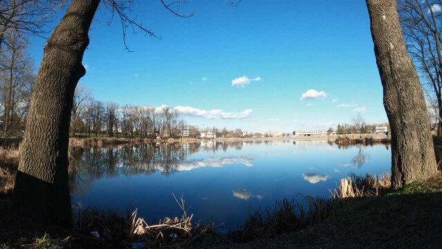 Time lapse footage of lake Bubanj surrounded with trees under blue cloudy sky