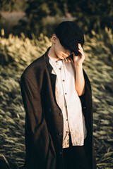 village boy in a cap 9 years old in a wheat field. holding a cap in his hand. close-up 