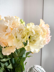 Photo of a delicate bouquet of white Eustoma flowers in vase on a white background