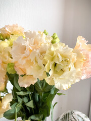 Photo of a delicate bouquet of white Eustoma flowers in vase on a white background