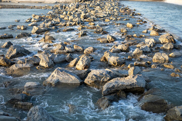 A rocky shoreline with a body of water in the background