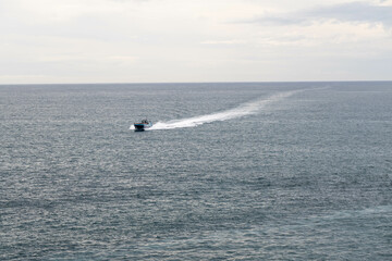 Motor boat on the ocean - horizon - sky and clouds