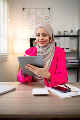 Young Muslim business woman hijab happy using digital tablet in modern office