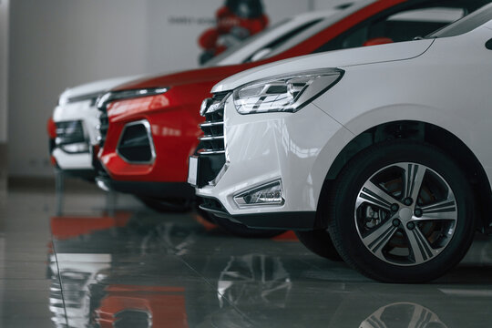 Fototapeta Side view of three cars that are parked in the auto salon