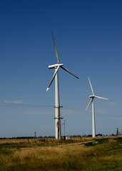 windmills with wind energy turbines in the countryside to generate clean energy