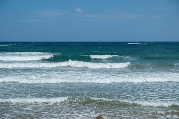 Tranquil tropical beach with crystal-clear waters and rolling waves lapping against the shore