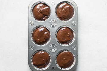 chocolate muffin batter in a cupcake tin, process of making chocolate muffins