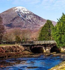Fototapeta na wymiar Scenic view of a majestic mountain rising in the distance near a bridge in Isle of Skye, Scotland,UK