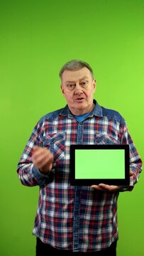 Man using tablet with green screen presentation.