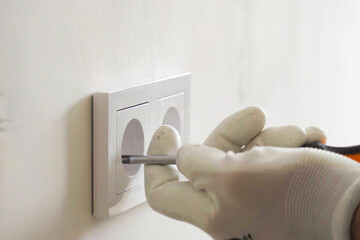 Installation of electric household socket on the wall during the renovation of the apartment