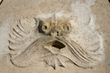 Sculpture incrustée dans la pierre de tête de monstre marin