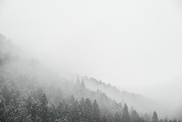 Stunning landscape of snow-covered mountains engulfed in a thick fog