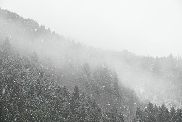Stunning landscape of snow-covered mountains engulfed in a thick fog
