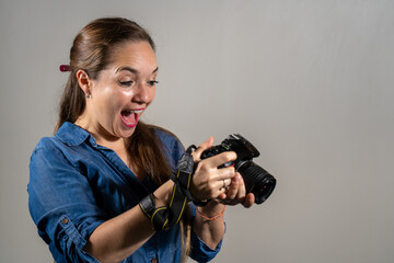 Mujer fotógrafa sorprendida revisando su cámara reflex