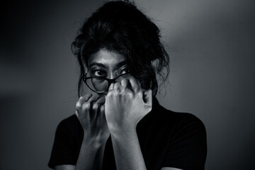 A woman with glasses and a black shirt is looking away from the camera