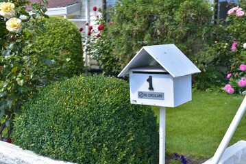 Traditional post box stands prominently amidst a lush, verdant lawn