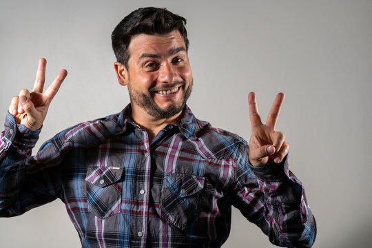 Hombre feliz haciendo una V con sus manos en se&ntilde;al de victoria y triunfo