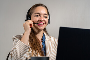 Mujer en una tele llamada, sonriente y mirando a cámara. Concepto de mesa de ayuda y asistencia virtual	