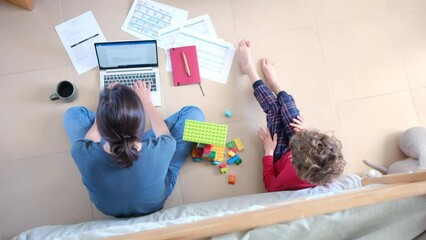 At-home working mom juggles professional tasks while nurturing and tending to her sons.