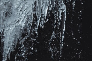 icicles are hanging from the wall of a frozen waterfall