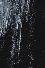 Closeup of the waterfall icicles on the background of rock