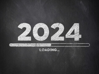 2023 Loading written with chalk on blackboard. 2024 themed work on a black background. new year celebration text