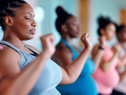 A group of diverse pregnant woman participating in a prenatal fitness class 