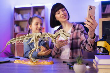 Young woman and little cute girl filming video of their scientific research. Happy mother examine...