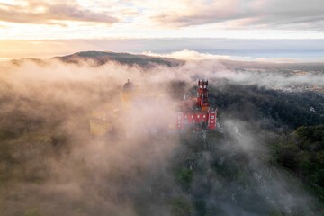 Naklejka premium Areal drone shot of Pena Palace in a vast fog