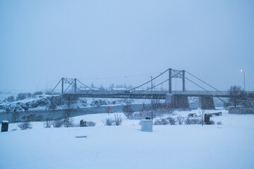 Selfoss suspension bridge across over the river in snowstorm or blizzard on winter