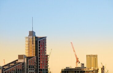 Fototapeta na wymiar Modern buildings and a contruction crane against the beautiful sunset sky