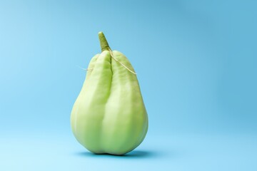 Chayote squash against a pastel blue backdrop. Green Chayote Squash on Blue