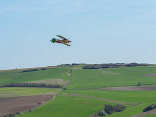 Avion de guerre allemand jaune rouge et vert en vol au-dessus des champs