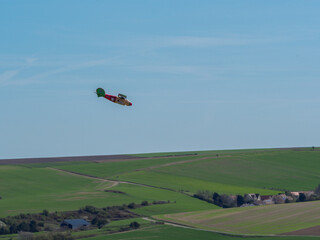 Avion de guerre allemand jaune rouge et vert en vol au-dessus des champs