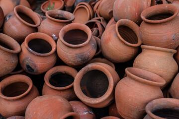 pots are gathered and arranged in a pattern in the empty space. The potter works on a pottery wheel to made of soft colored clay, retro style toned Clay pots with hand and equipment
