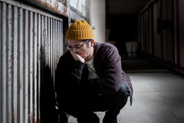 落ち込んでしゃがみ込む男性