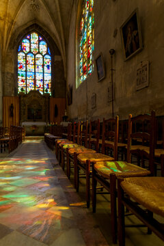 Chaises &eacute;clair&eacute;es de la lumi&egrave;re des vitraux dans la cath&eacute;drale de L'Aigle en Normandie