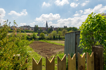 Vue au-dessus de la barrière de bois d'un potager avec la terre labourée