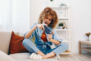 Cozy Living: Woman Holding Mobile Phone, Smiling, Enjoying Leisure Time on Sofa in Home