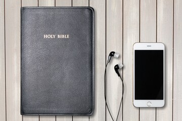 Christian online concept. Earphones, holy bible and smartphone.