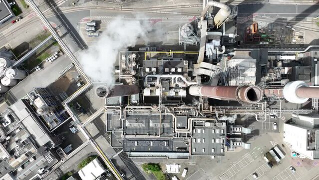 Smokestacks of the iconic consumer goods factory in Dusseldorf, Germany. Chemical factory and facility. Aerial top down drone view of heavy industrial installation. Containers and silos.