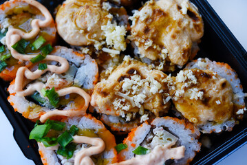 Fish rolls with sauce. Japanese sushi rolls. Rice breakfast of rolls.