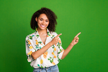 Photo of cheerful pretty woman dressed print shirt pointing two fingers empty space isolated green color background