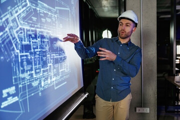 Modern exterior. Man architect in hard hat is near projector with construction plan