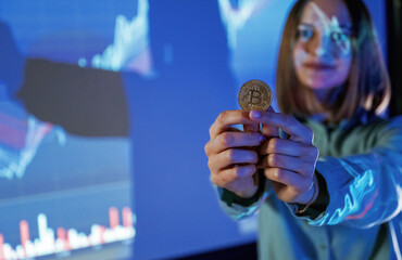 Positive female is with digital currency coin. Businesswoman is against projector with graphs,...
