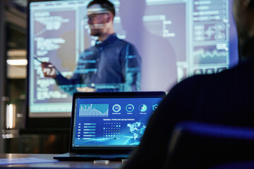 Talking about project. Male business trainer is against projector with data, teaching people